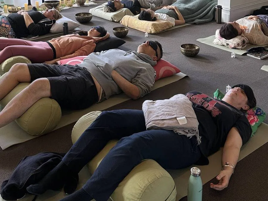 Community sound bath with people resting in the studio