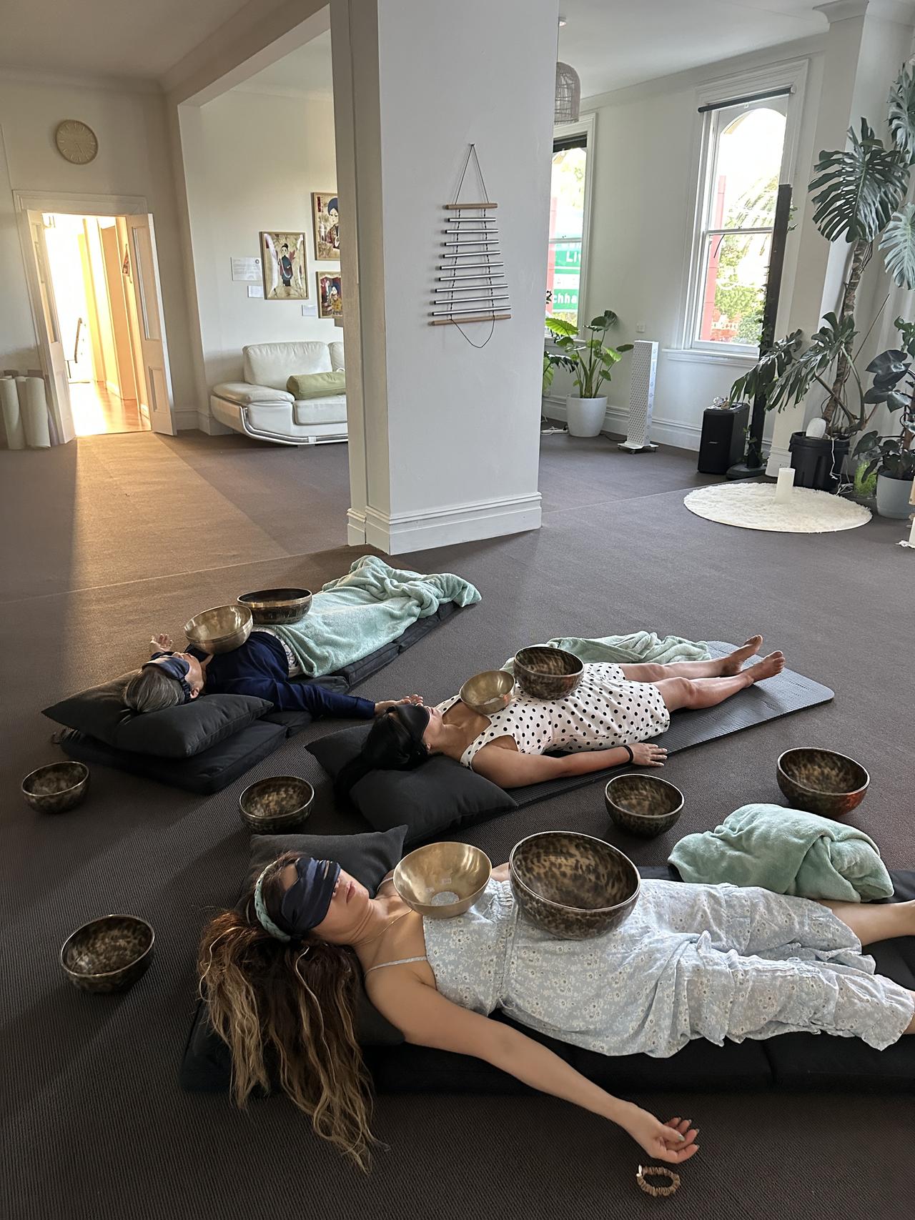 Private sound healing session with singing bowls placed on guests at Mystic Wellness Petersham