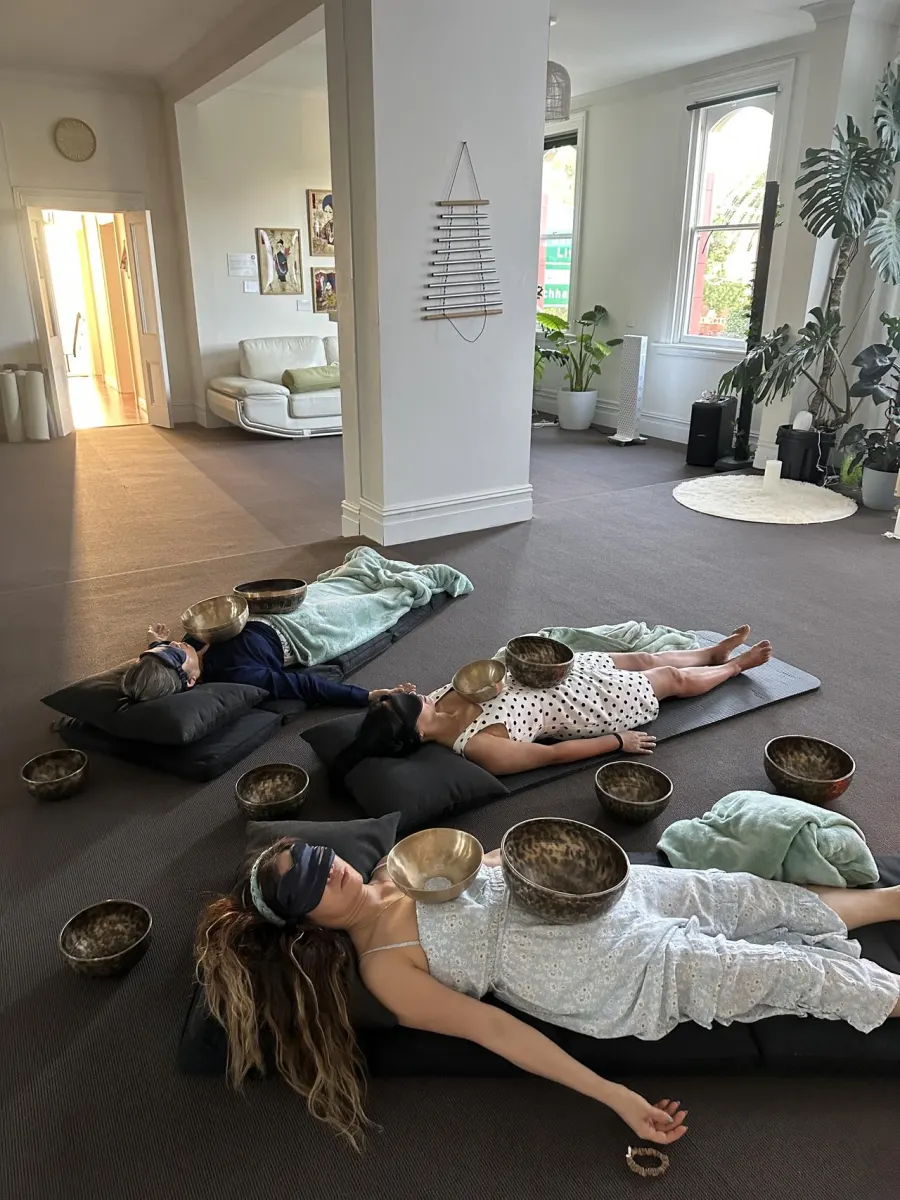 Private sound healing session with singing bowls placed on guests at Mystic Wellness Petersham