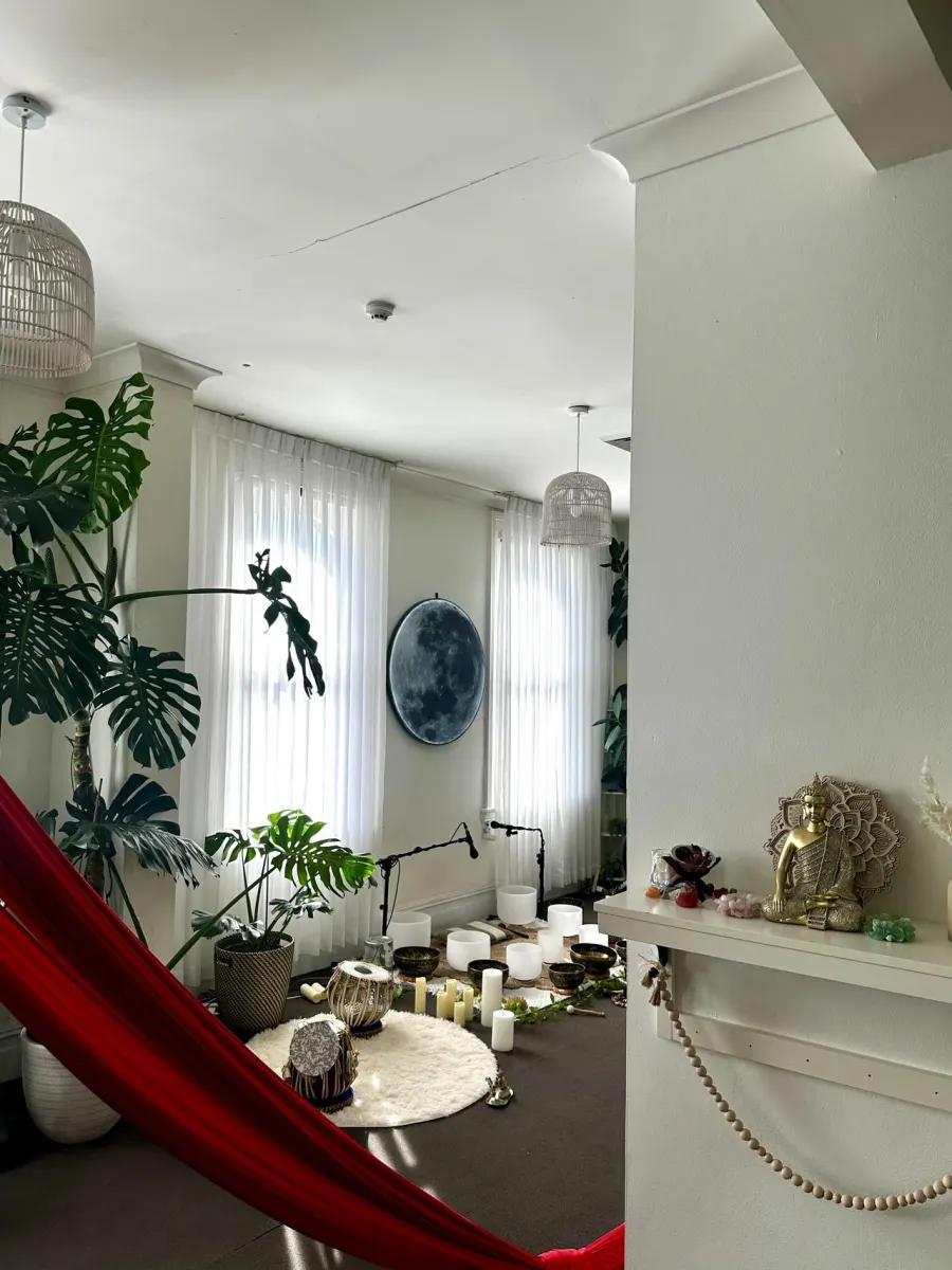 Light-filled Mystic Wellness studio rental space with moon wall, plants, candles, and healing instruments in Petersham